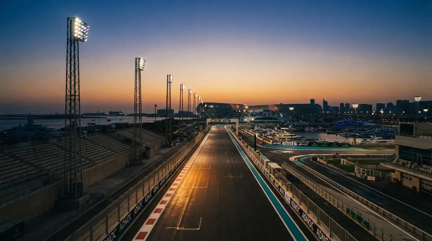 An empty football stadium with floodlight masts at dusk